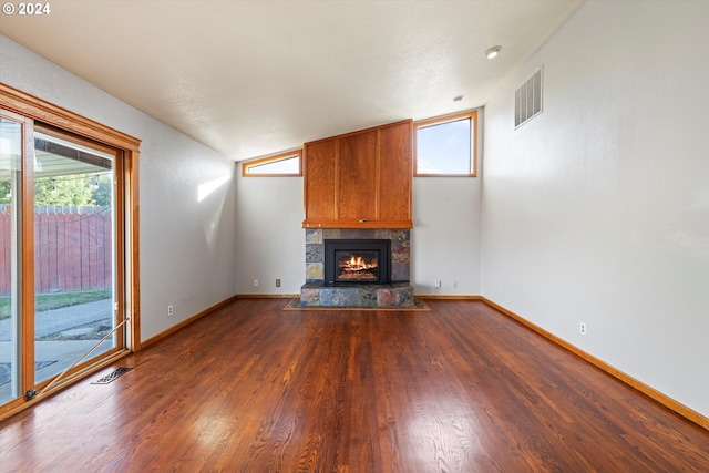 unfurnished living room with dark hardwood / wood-style floors, a large fireplace, lofted ceiling, and a textured ceiling