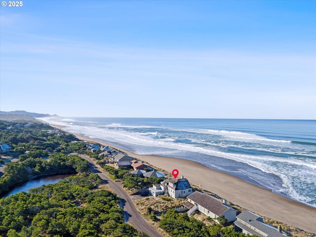 birds eye view of property with a water view and a view of the beach