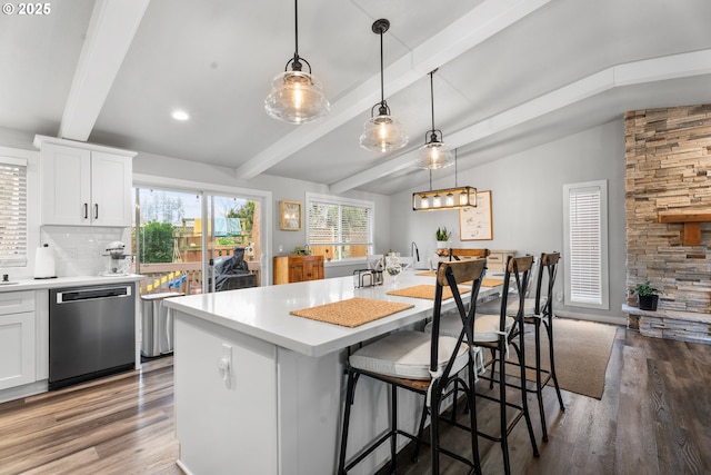 kitchen featuring a kitchen island with sink, white cabinets, pendant lighting, and dishwasher