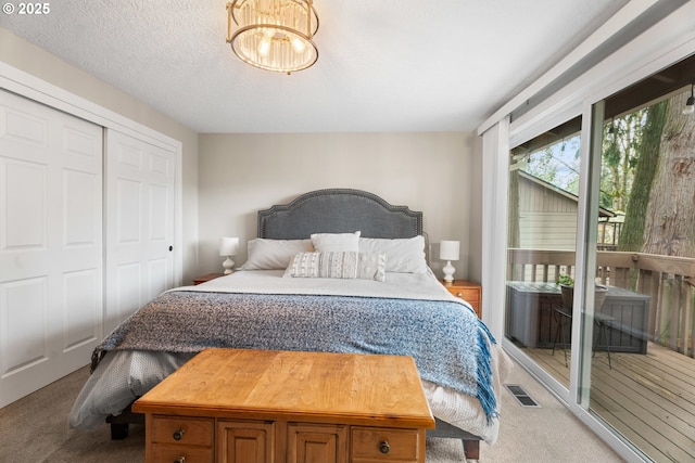 bedroom with access to outside, a closet, a textured ceiling, and carpet