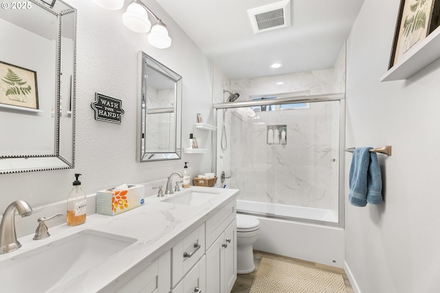 full bathroom featuring vanity, hardwood / wood-style floors, shower / bath combination with glass door, and toilet