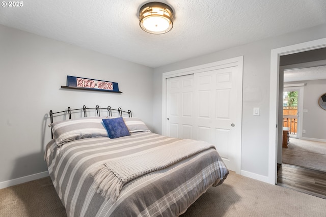 carpeted bedroom with a textured ceiling and a closet