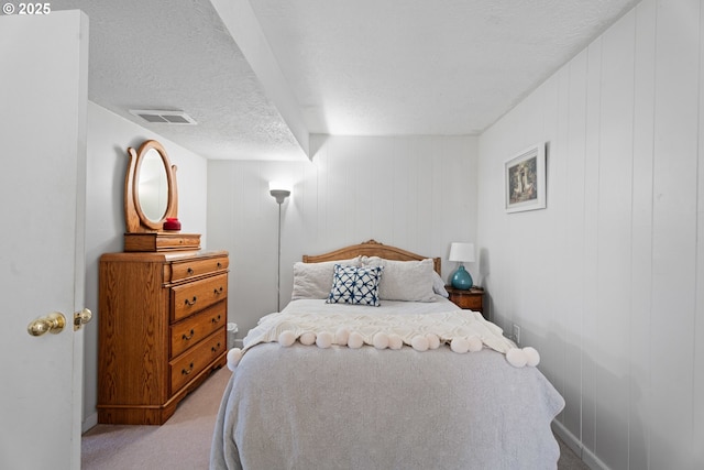 bedroom featuring light colored carpet and a textured ceiling