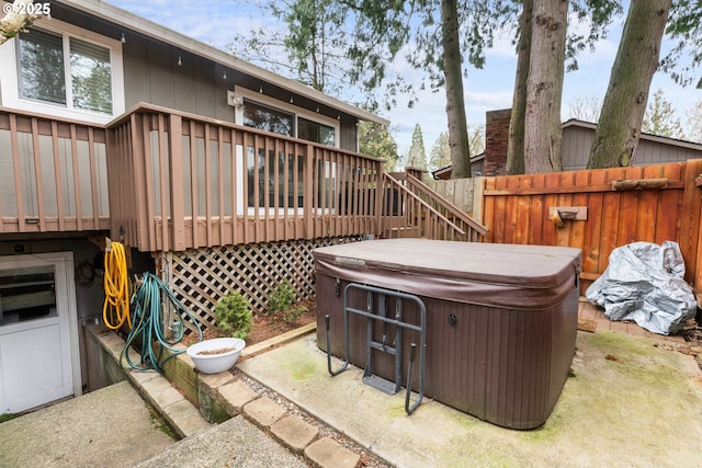 view of patio / terrace with a hot tub and a deck