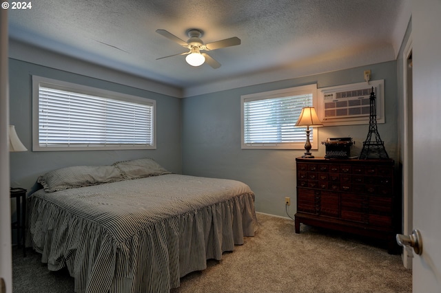 bedroom with ceiling fan, an AC wall unit, and light carpet