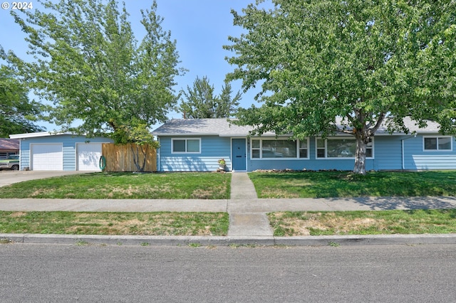 single story home with a garage and a front lawn