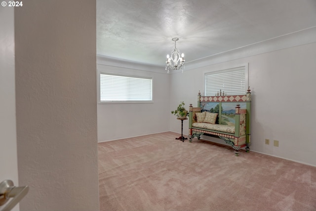 sitting room featuring carpet floors and an inviting chandelier