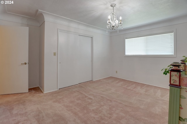 unfurnished bedroom with a chandelier, a closet, and light colored carpet