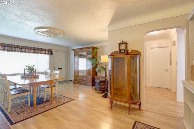 dining area featuring wood-type flooring and a textured ceiling