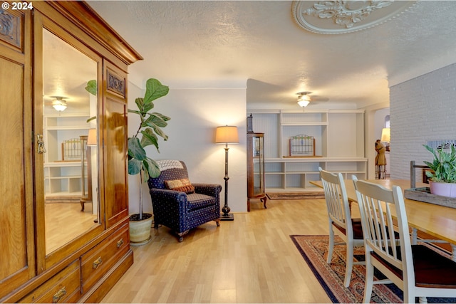 dining space with light wood-type flooring and a textured ceiling