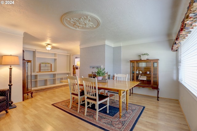 dining area featuring a textured ceiling and hardwood / wood-style flooring