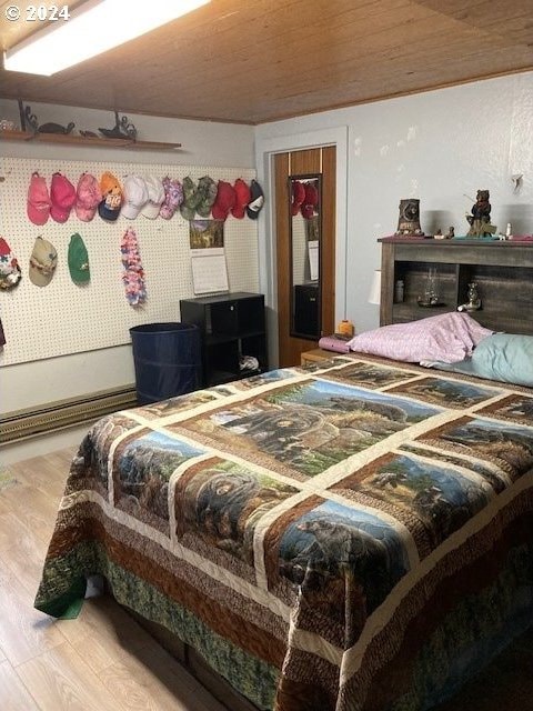 bedroom with wooden ceiling and light hardwood / wood-style flooring