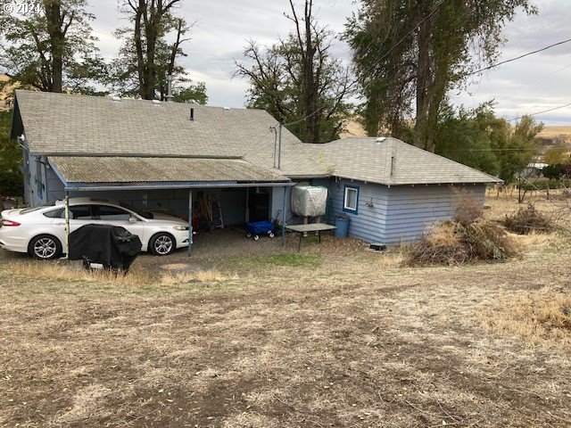 back of house featuring a carport