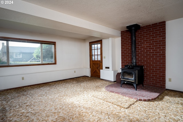 unfurnished living room featuring plenty of natural light, carpet floors, and a textured ceiling