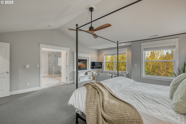 carpeted bedroom featuring vaulted ceiling, ensuite bath, and ceiling fan