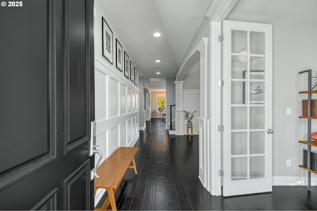 hallway with a textured ceiling and dark hardwood / wood-style flooring