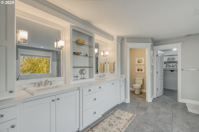 bathroom with vanity, toilet, and a textured ceiling