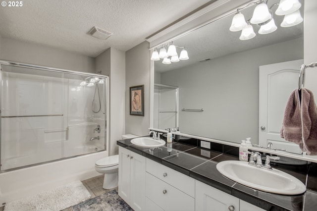 full bathroom with toilet, vanity, a textured ceiling, and combined bath / shower with glass door