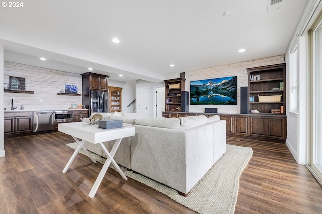 living room with recessed lighting, dark wood finished floors, and wood walls