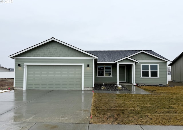 ranch-style house featuring a garage, concrete driveway, roof with shingles, and a front lawn