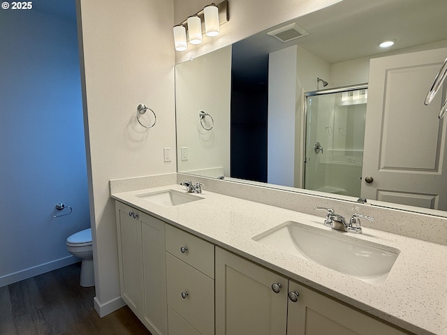 bathroom with visible vents, a sink, a shower stall, and toilet