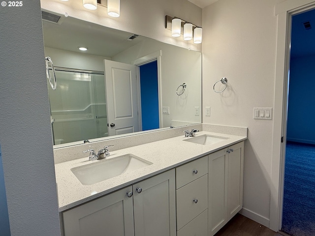 full bathroom with visible vents, a sink, baseboards, and an enclosed shower