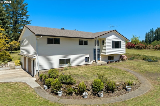 rear view of house with a garage and a lawn