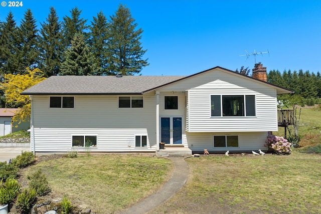 bi-level home with a front lawn and french doors