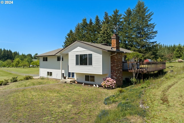 rear view of property with a yard and a deck