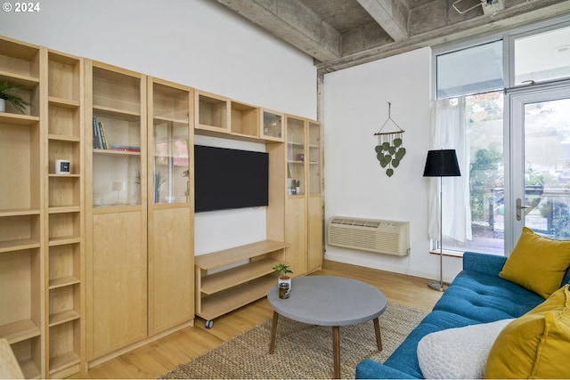 living room with an AC wall unit and light wood-type flooring