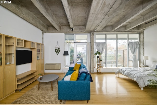 bedroom with a wall mounted air conditioner and hardwood / wood-style flooring