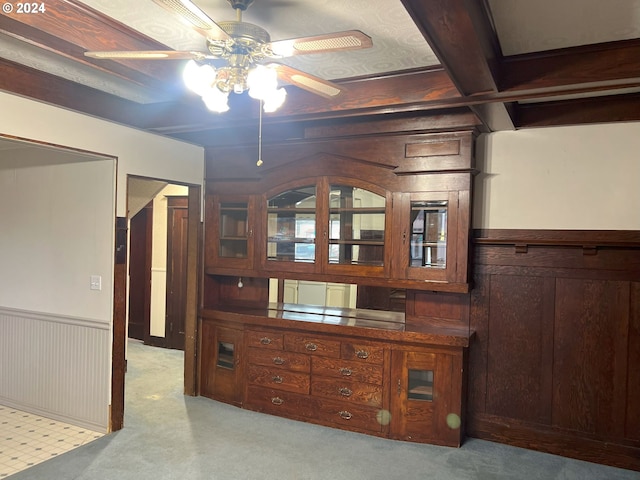 interior space with beamed ceiling, light colored carpet, and wooden walls