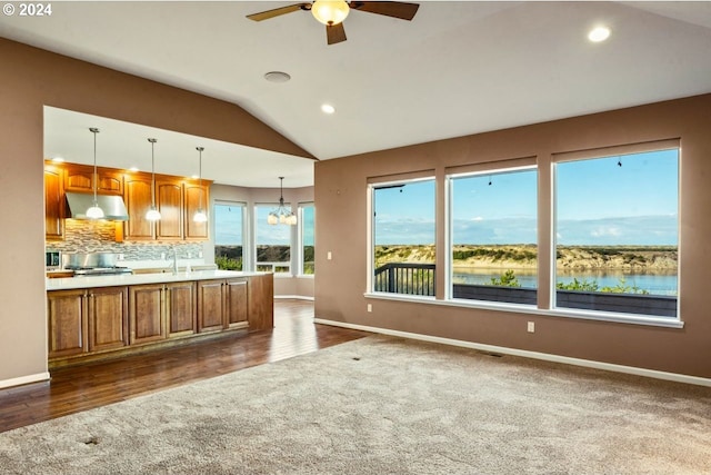 kitchen with ceiling fan with notable chandelier, dark hardwood / wood-style flooring, lofted ceiling, and hanging light fixtures