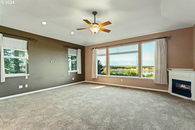 unfurnished living room featuring carpet, ceiling fan, and a healthy amount of sunlight