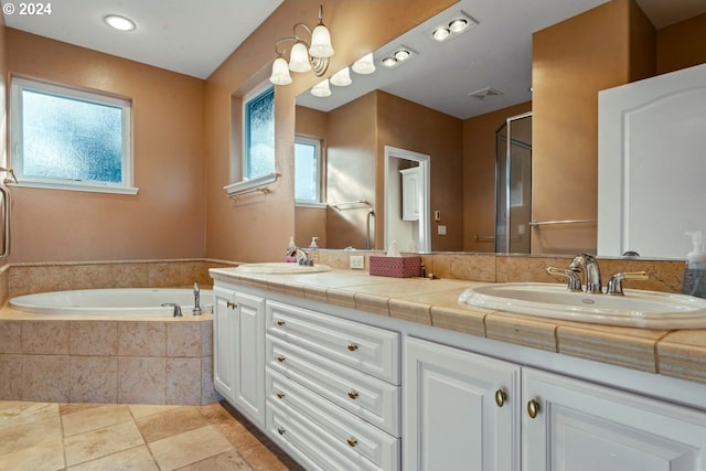 bathroom featuring vanity, tile patterned floors, and tiled tub