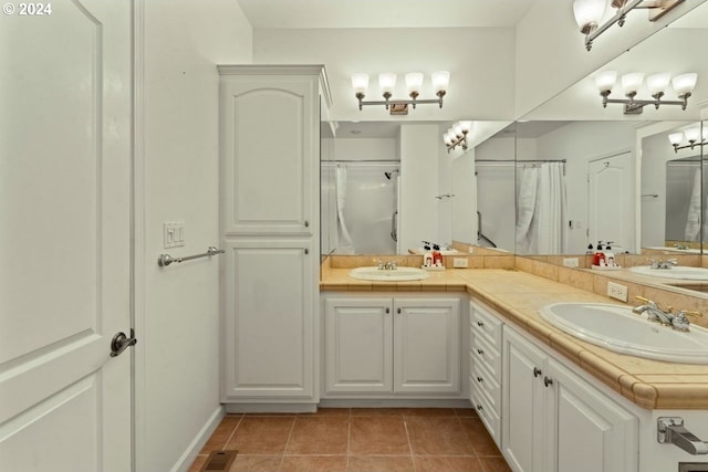 bathroom featuring tile patterned flooring, vanity, and walk in shower