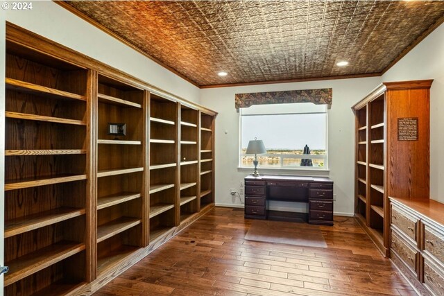 unfurnished office featuring crown molding and dark wood-type flooring