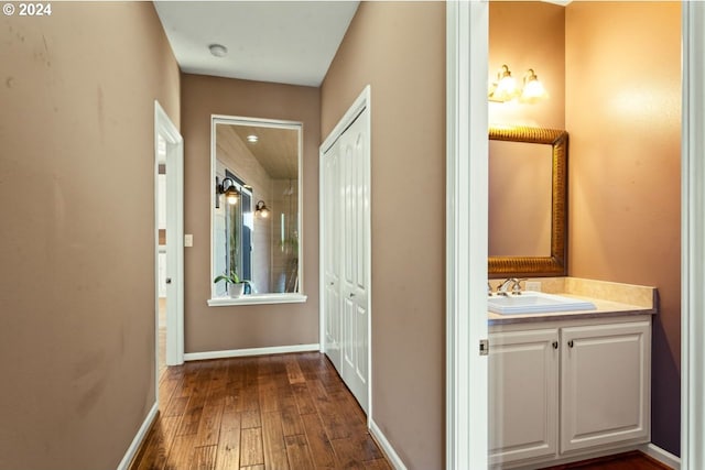 corridor with sink and dark wood-type flooring