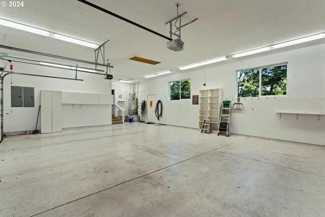 garage with electric panel, strapped water heater, and a garage door opener