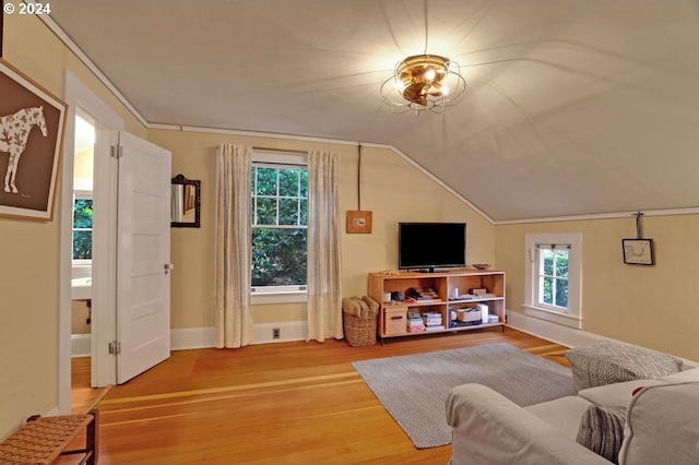 living room featuring wood-type flooring, ornamental molding, and vaulted ceiling