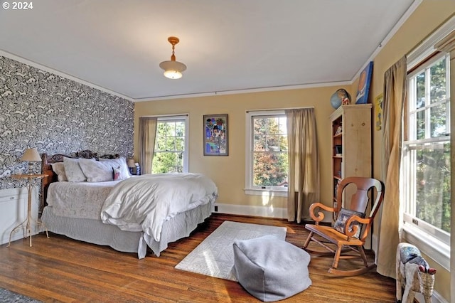 bedroom with dark hardwood / wood-style flooring and ornamental molding