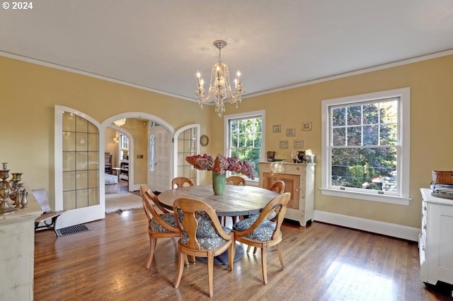 dining area featuring crown molding, a chandelier, and dark hardwood / wood-style flooring