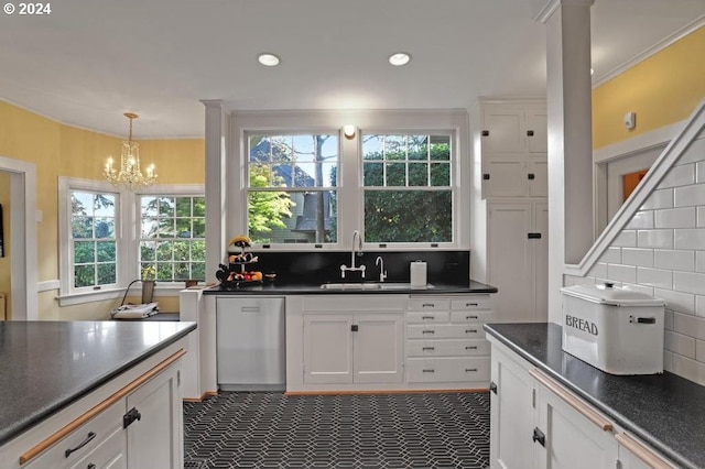 kitchen with pendant lighting, tasteful backsplash, sink, white cabinets, and stainless steel dishwasher