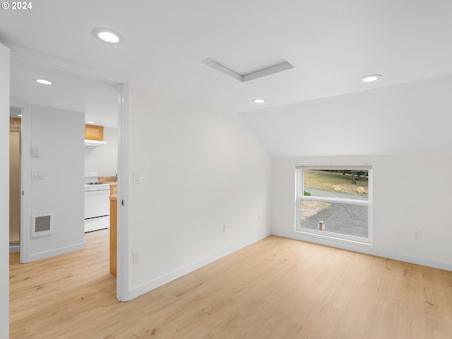 unfurnished room with vaulted ceiling and light wood-type flooring