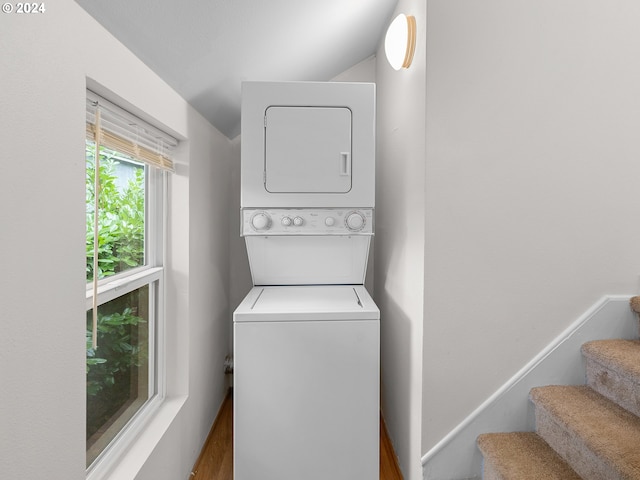 clothes washing area featuring stacked washer / drying machine