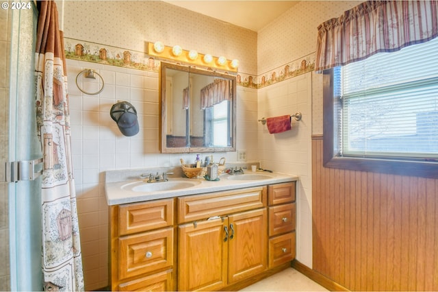 bathroom with vanity, tile walls, and a wealth of natural light