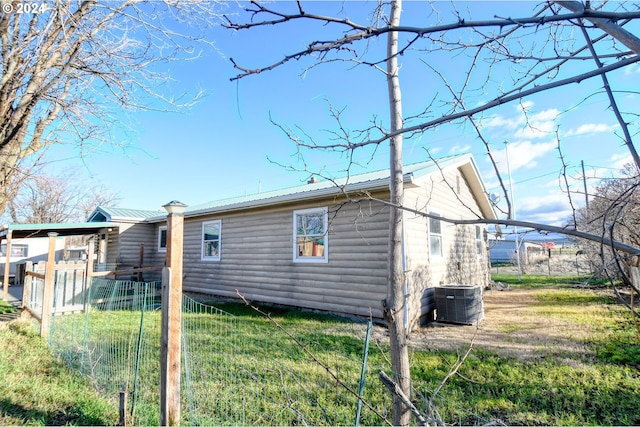 view of property exterior featuring central AC unit and a yard