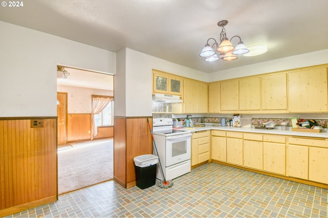 kitchen featuring a chandelier, electric range, decorative light fixtures, and wooden walls