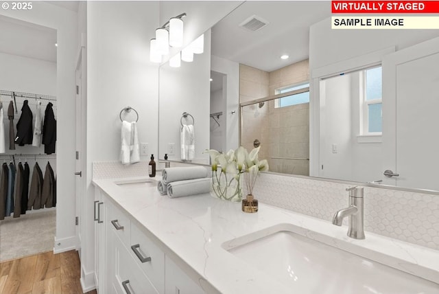 bathroom featuring vanity, wood-type flooring, and a shower with door