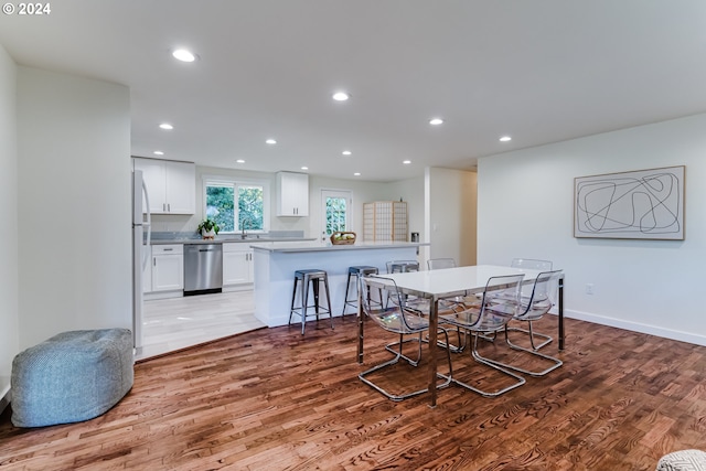 dining area with sink and light hardwood / wood-style floors